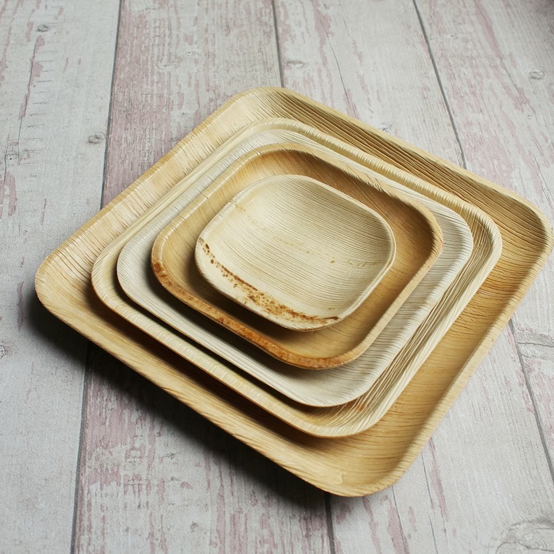 A stack of NZR's biodegradable palm-leaf plates — multiple sizes, fully compostable.
