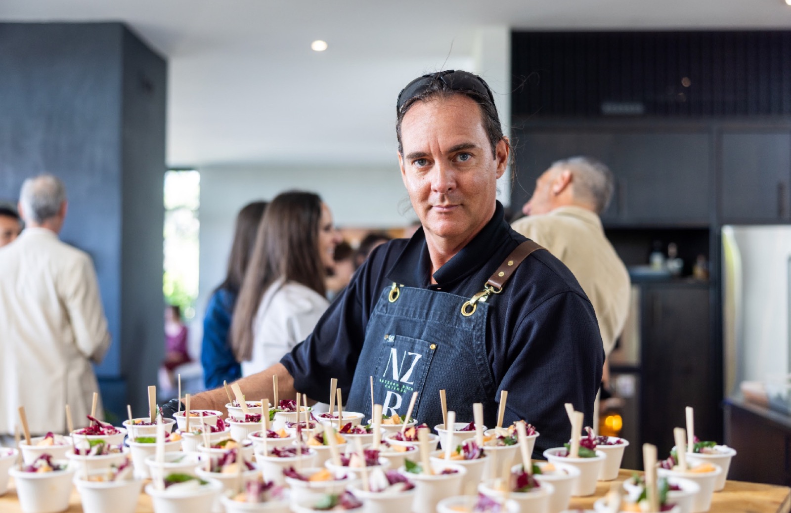 A Net Zero Ranch crew member behind rows of styled salad cups.