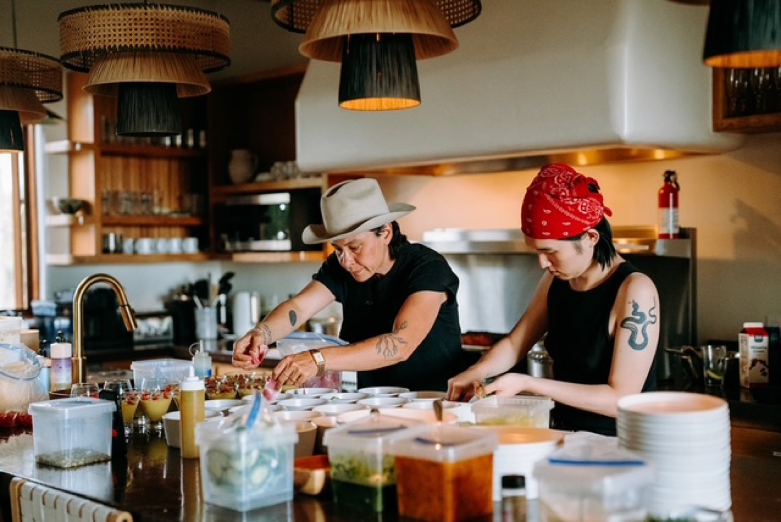 Two Net Zero Ranch crew members prepping a menu in the kitchen.