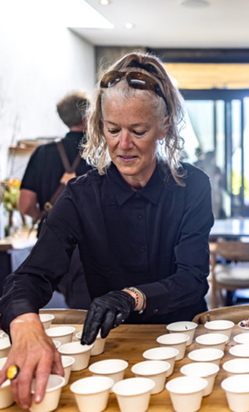 Kennedy plating rows of chilled soup shooters at a Net Zero Ranch event.
