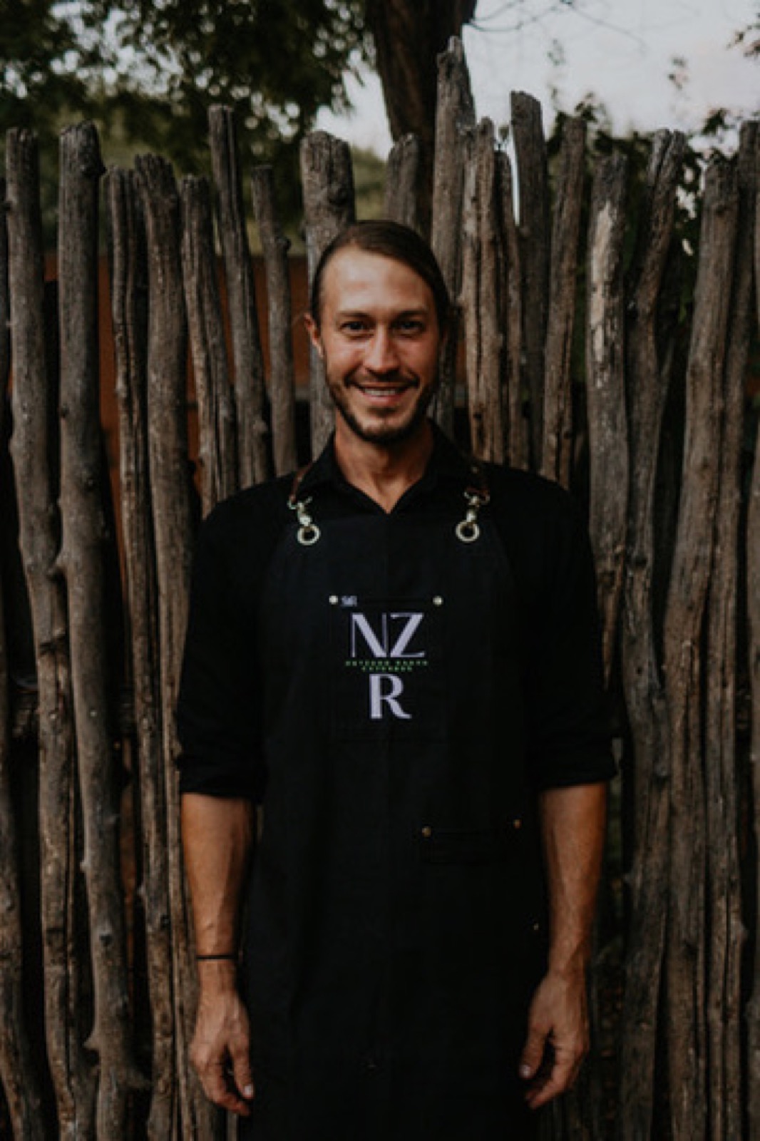 A Net Zero Ranch crew member in the NZR apron, portrait.