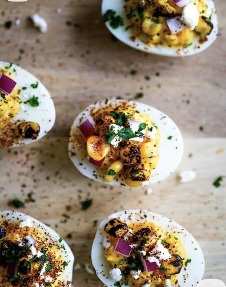Deviled eggs topped with charred elote, red onion, cotija, and Tajín.