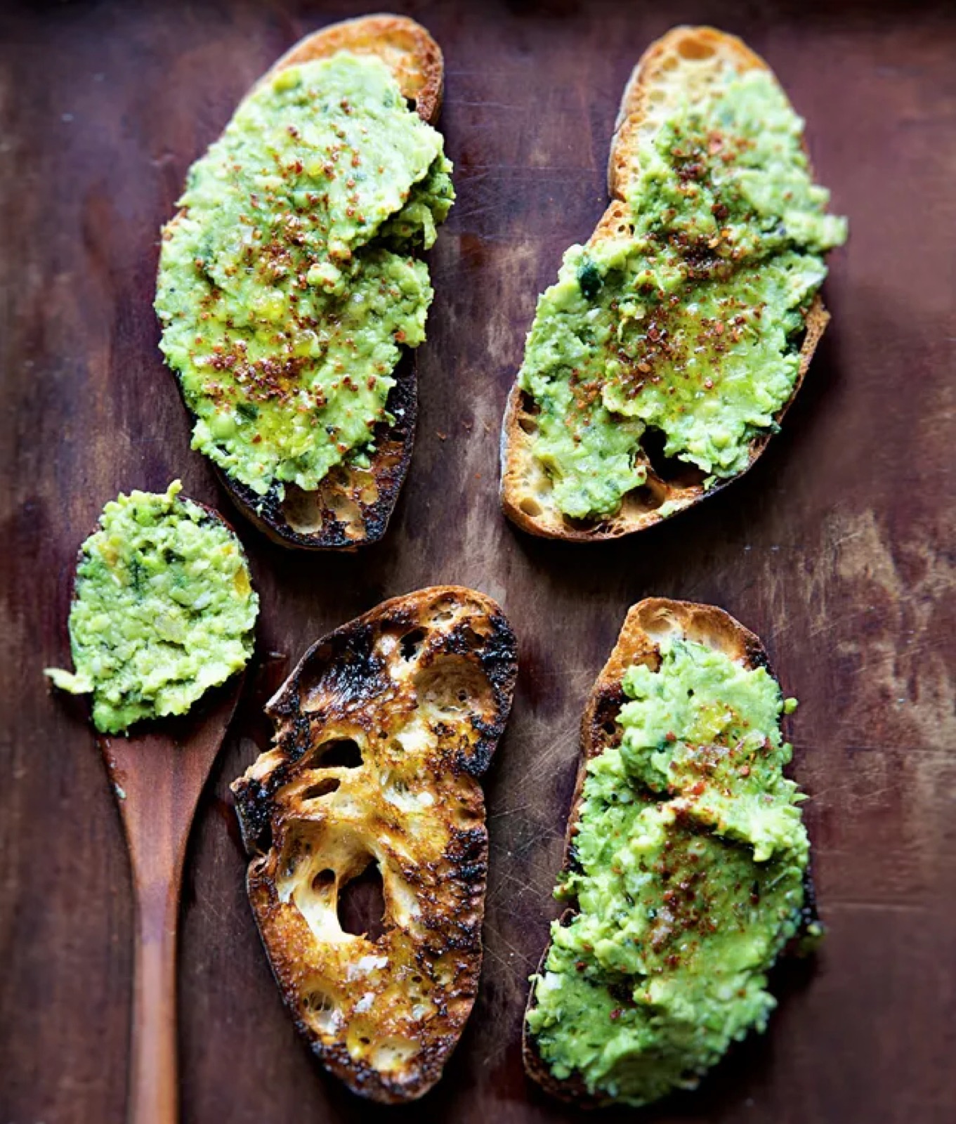 Smashed pea bruschetta on charred bread — appetizer station.