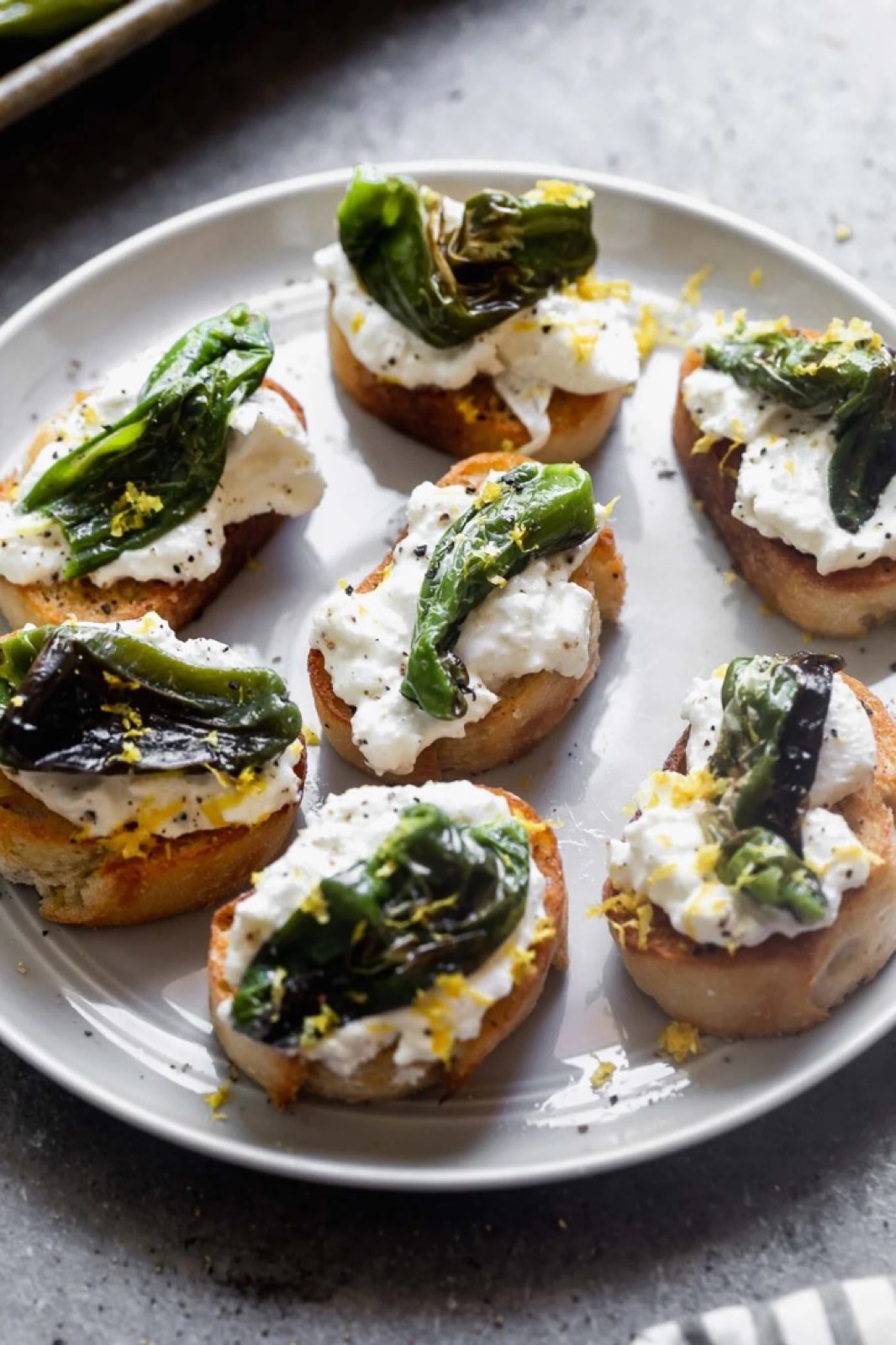 Blistered shishito & ricotta bruschetta with lemon zest — appetizer station.