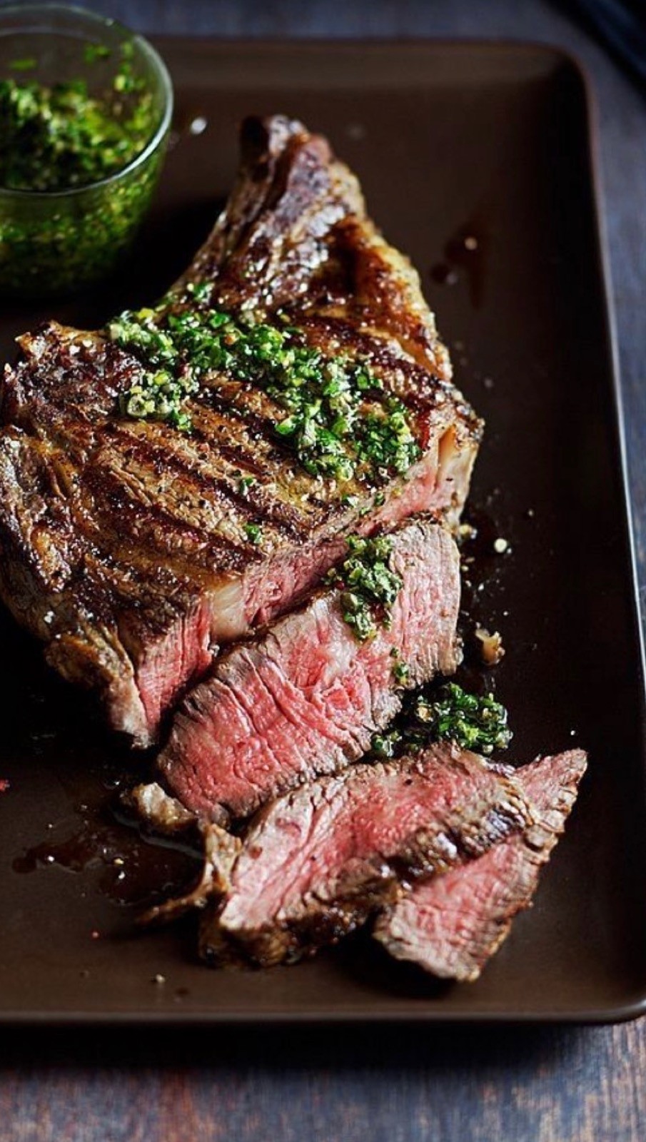 Sliced bison ribeye, seared on the plancha, with chimichurri — The Asado.
