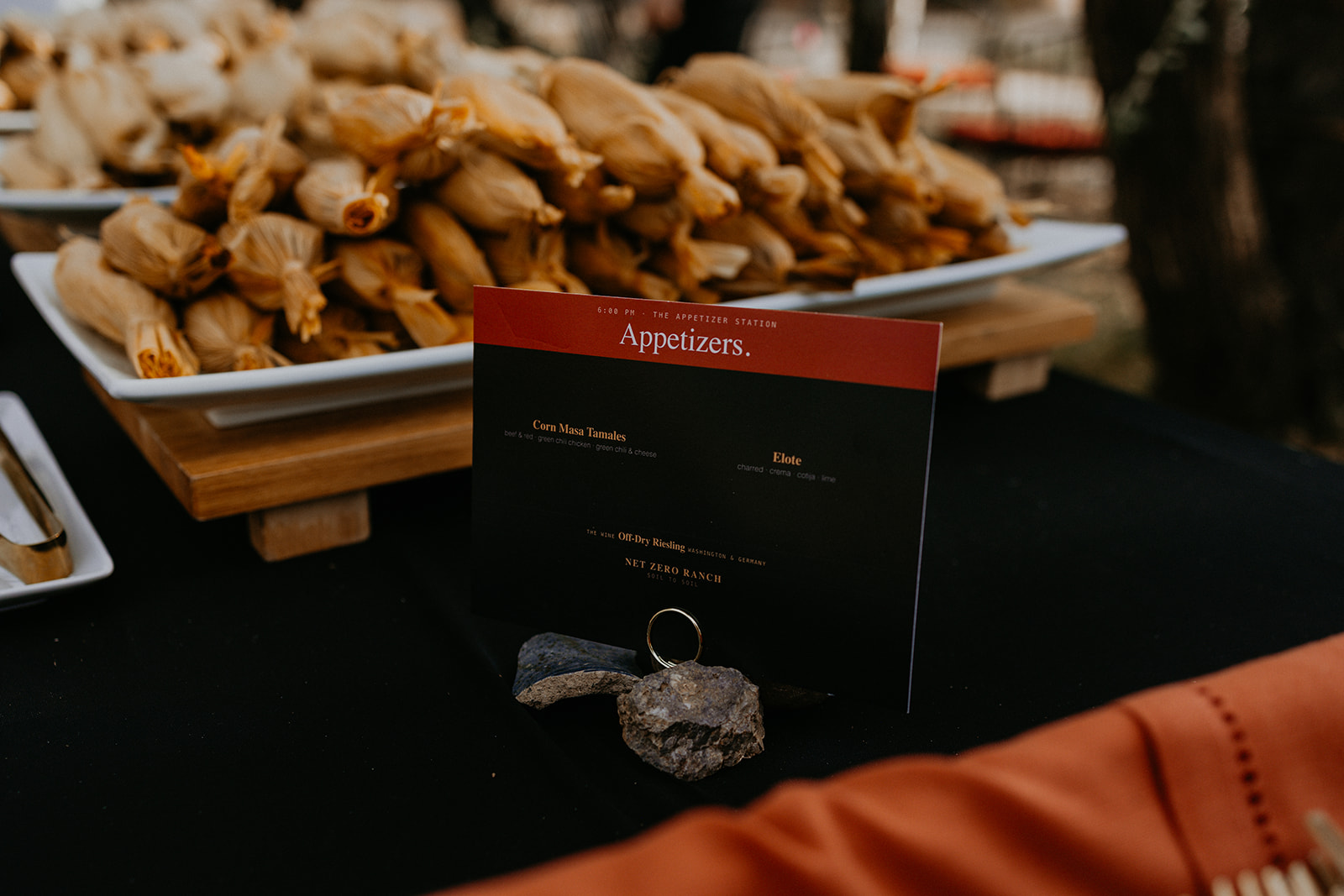 Platters of corn masa tamales with the Net Zero Ranch menu card — appetizer station.