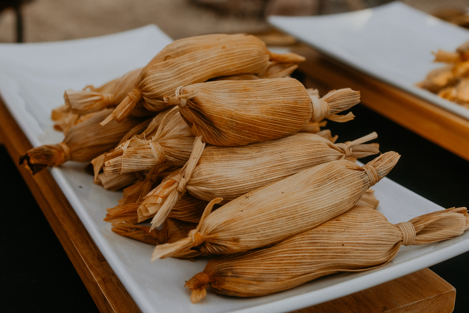 Green chili cheese tamales in corn husks, served at a Net Zero Ranch buffet.