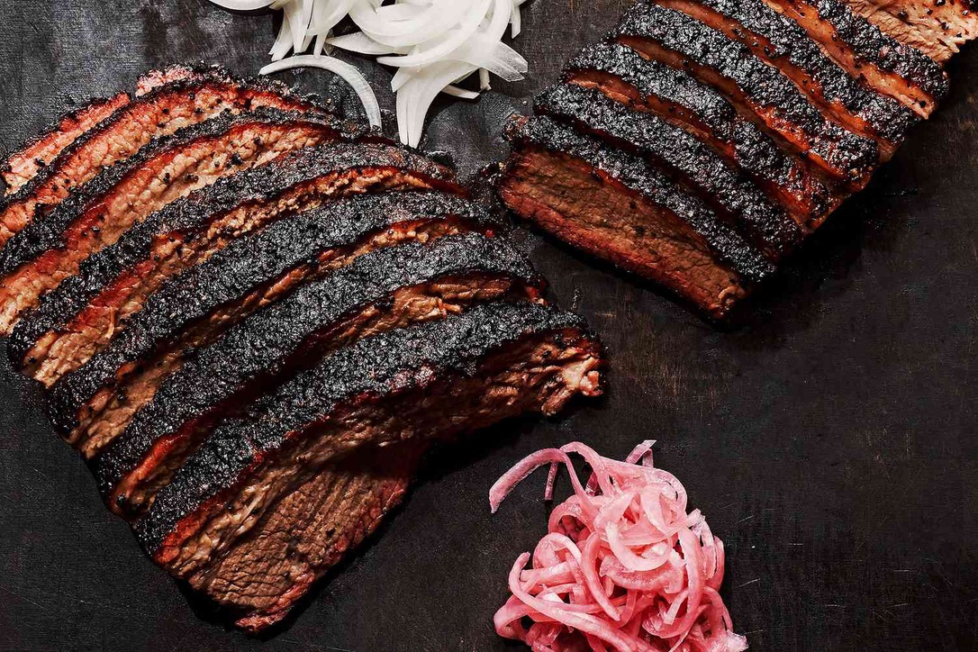 Sliced wood-smoked brisket with white onions and pickled red onions — The Estancia.
