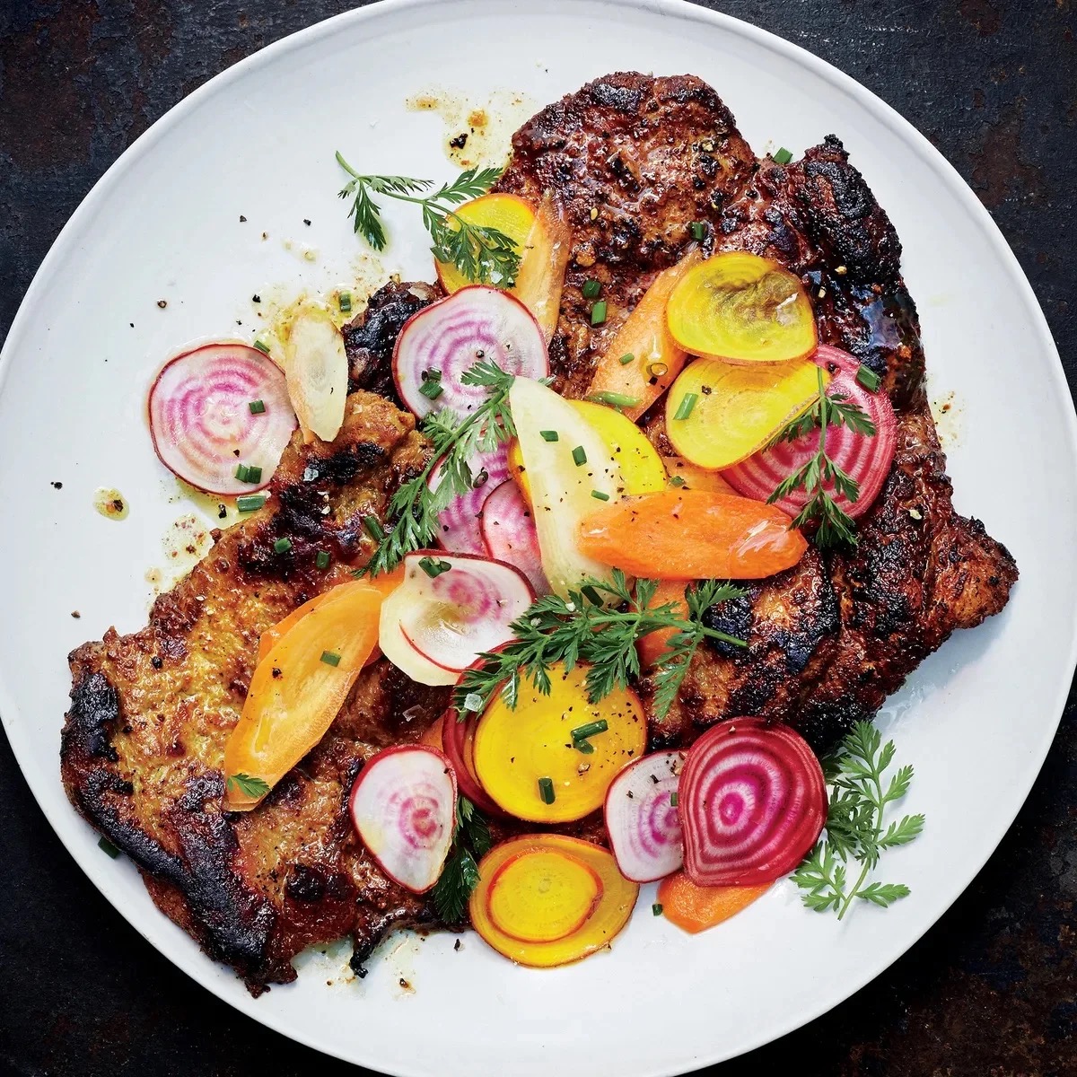 Wood-fired sliced steak with chioggia and golden beets, shaved radish, baby carrots, and chives — Net Zero Ranch.