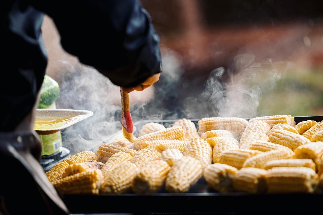 Sweet corn steaming over the fire, turned by a Net Zero Ranch chef.