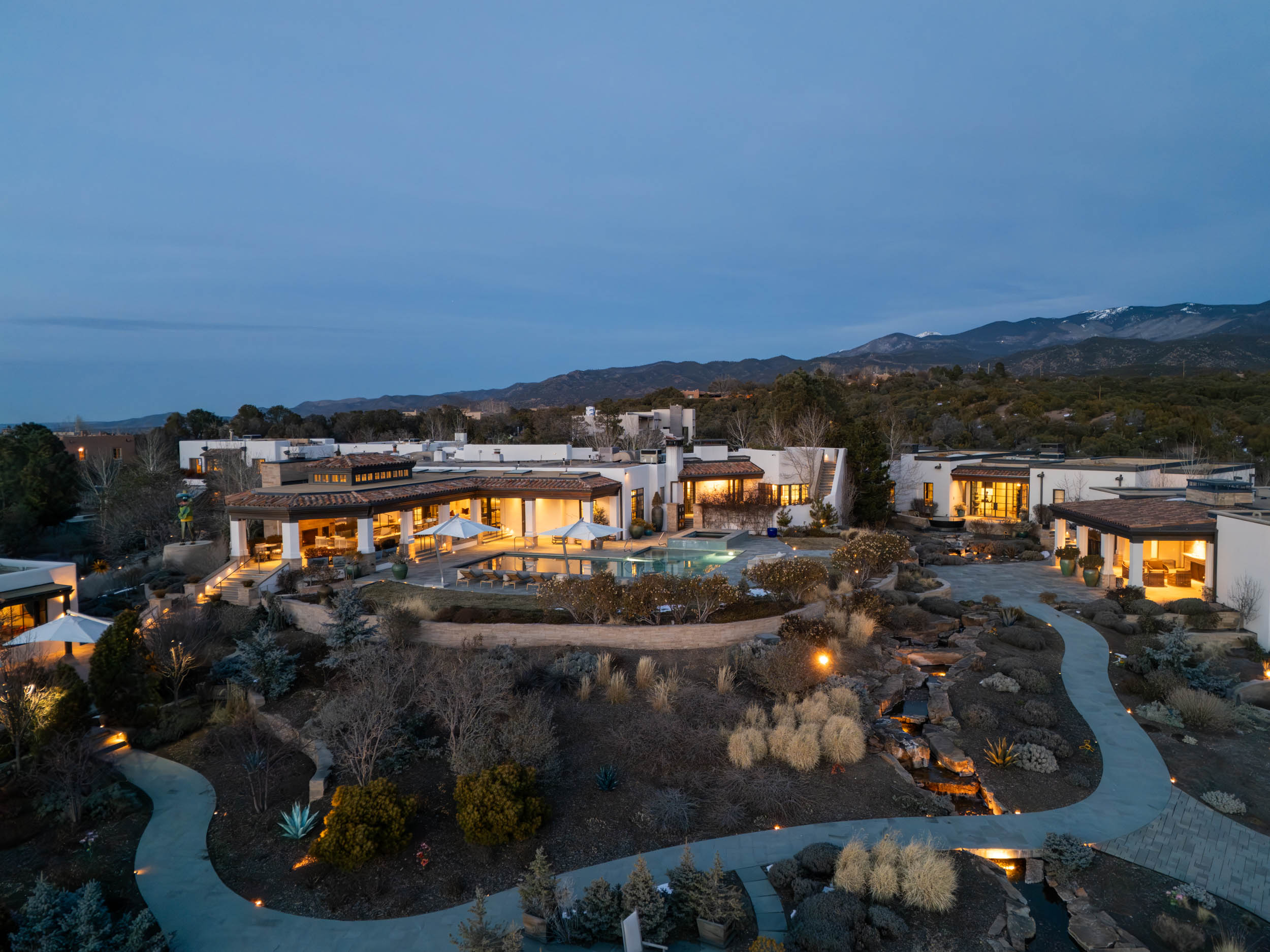 Casa Estrella del Norte estate at dusk with pool and mountain views, Santa Fe.