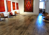 Shiprock Santa Fe gallery — Navajo textiles and weavings on white walls with wood floors.