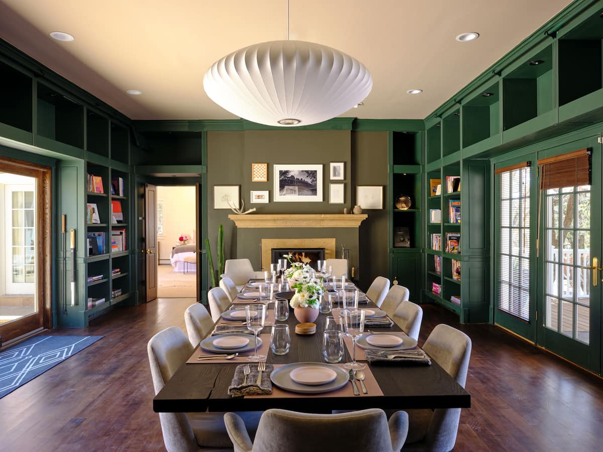 The Ridge, Santa Fe — a green-library dining room with a contemporary art wall, set for dinner.